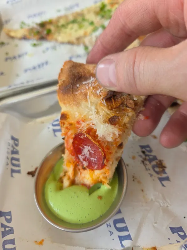 Bout de croûte au pepperoni trempé dans une sauce maison verte aux herbes